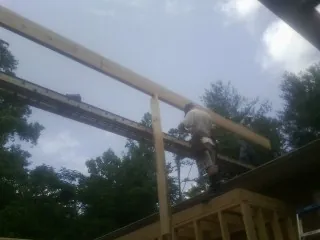 Carpenter setting a ridge beam over a new addition frame — Ice Dam Removal by Roofing Brothers in Gatesville