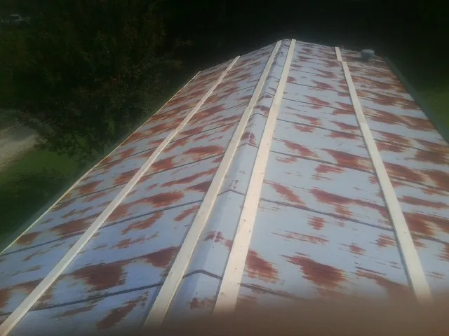 Rusted metal roof panels with new wood purlins before replacement — Storm Damage Roof Repair in Gatesville by Roofing Brothers