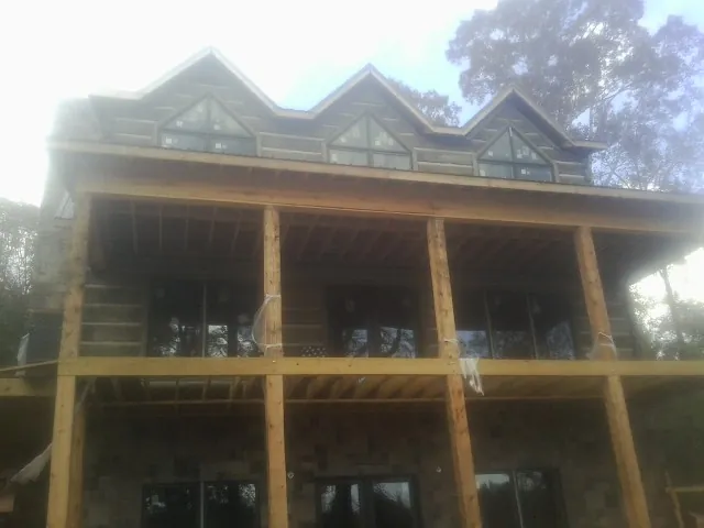 Dormers and porch framing on a large log home under construction — Roof Coating work by our crew in Gatesville