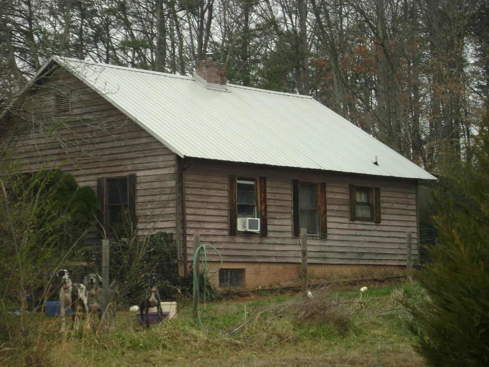 White metal roof on an old wood sided farmhouse, from a Metal Roof Installation job in Gatesville